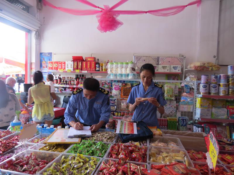 图为食药监所工作人员对副食品店进行检查